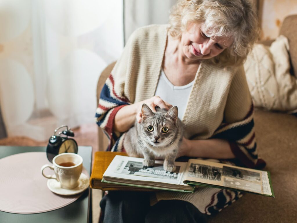Idosa fazendo carinho em um gato
