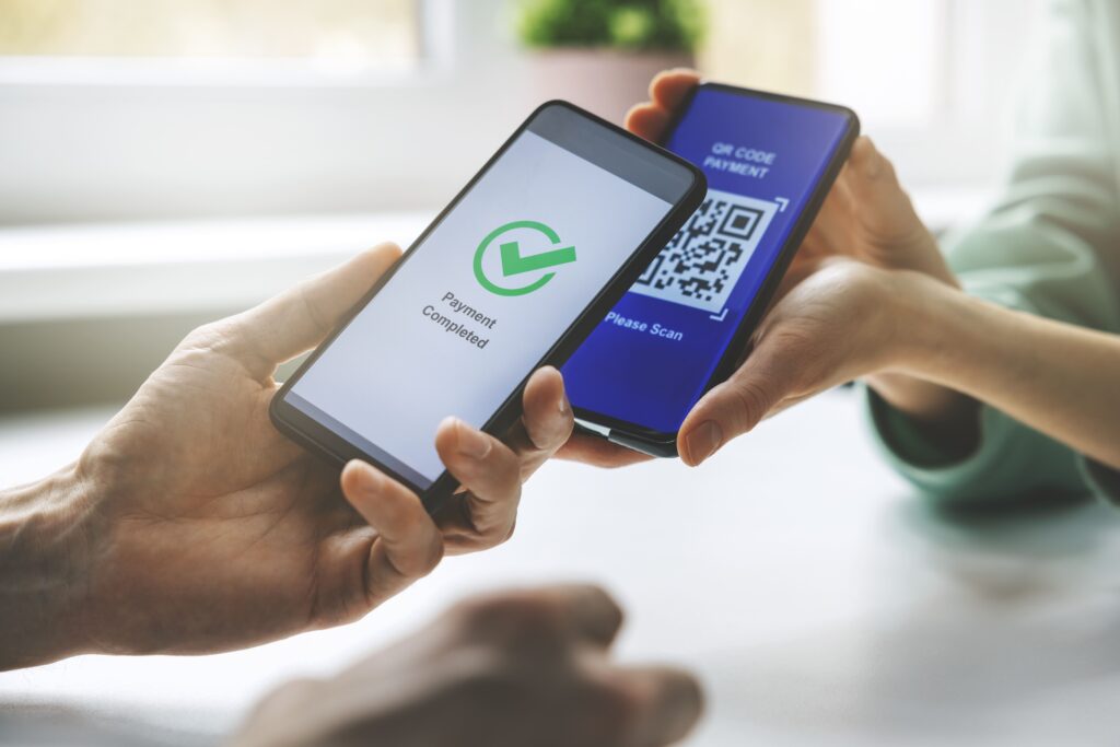 Uma pessoa fazendo pagamento via QR Code com um smartphone
