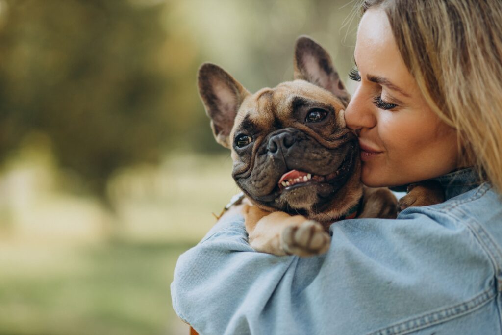 Mulher abraçando e beijando seu cão