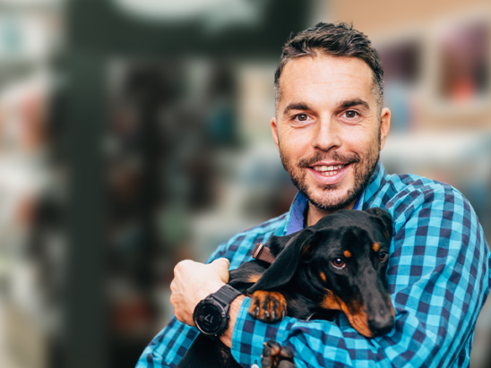Homem segurando cão no petshop