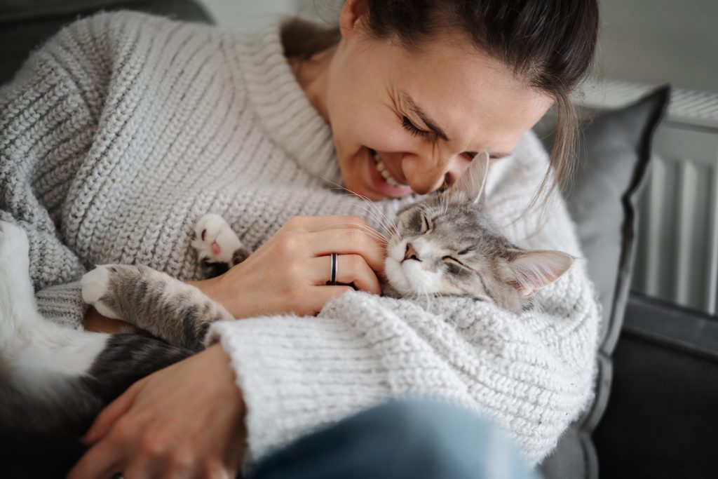 Tutora dando carinho ao gato em seu colo